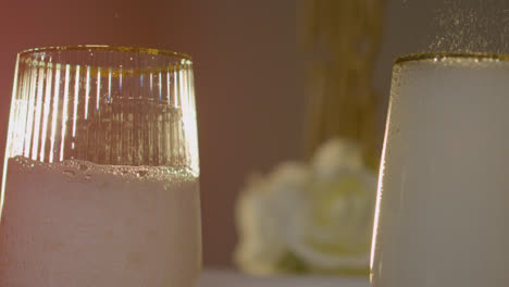 Close-Up-Of-Person-Pouring-Champagne-Into-Glasses-At-Table-Set-For-Meal-At-Wedding-Reception